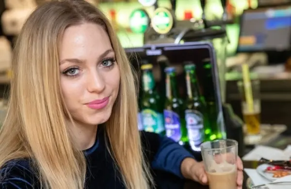 Mosolygó szőke nő a bárpult előtt