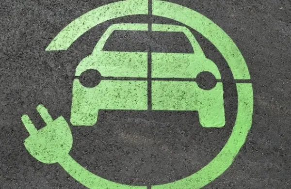 Zöld elektromos autótöltő jelzés az aszfalton
