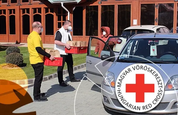 Önkéntesek ételadományt pakolnak a Magyar Vöröskereszt autójába