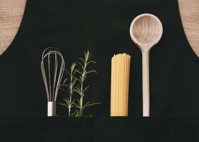 Habverő, rozmaring, spagetti és fakanál fekete háttéren